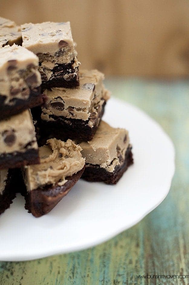 A stack of cookie dough brownies on a white plate.