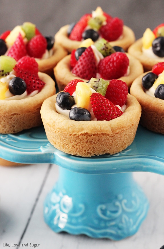 Mini Fruit Cheesecake Sugar Cookie Cups on a blue cake stand