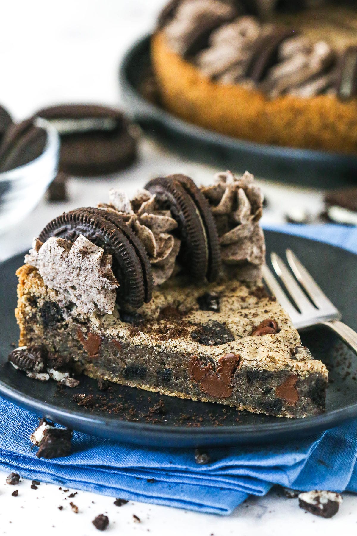 With an Oreo and chocolate chip cookie base and Oreo buttercream on top, this Oreo Cookie Cake is moist, chewy & irresistible. A slice of Oreo cookie cake on a plate