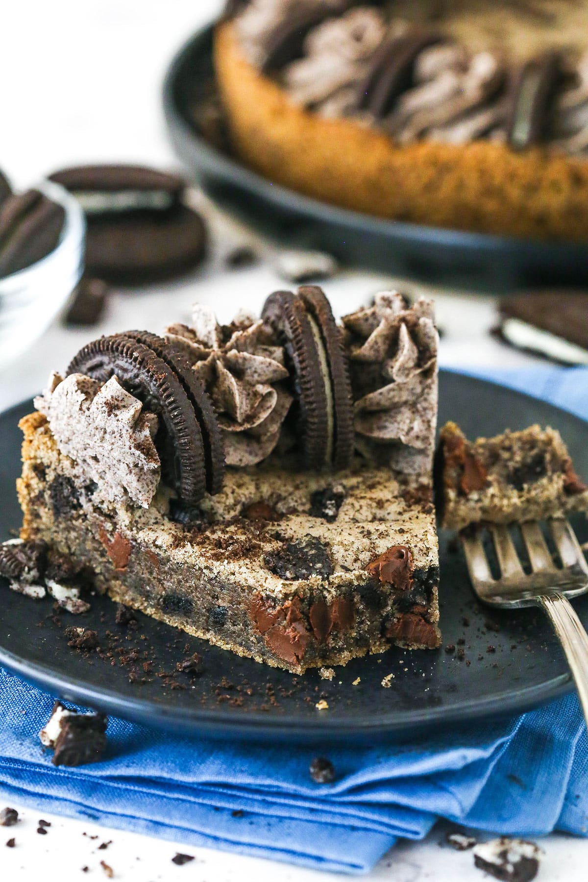 With an Oreo and chocolate chip cookie base and Oreo buttercream on top, this Oreo Cookie Cake is moist, chewy & irresistible. A slice of Oreo cookie cake with a piece on a fork