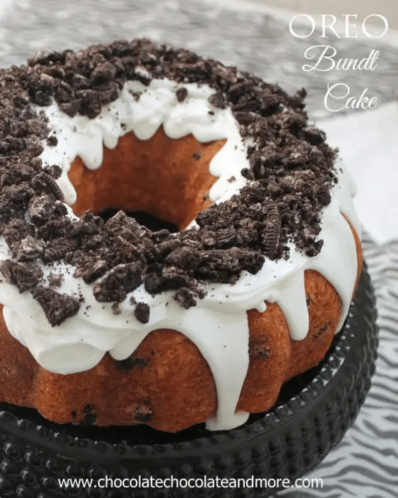 A decorated Oreo Bundt Cake on a black cake plate with text overlay for Pinterest.