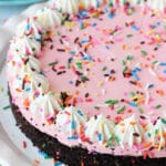 Overhead view of a full No Bake Strawberry Milkshake Cheesecake on a white platter