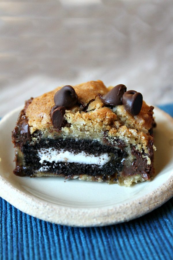Close up of an Oreo and Caramel Stuffed Chocolate Chip Cookie Bar on a small white plate.