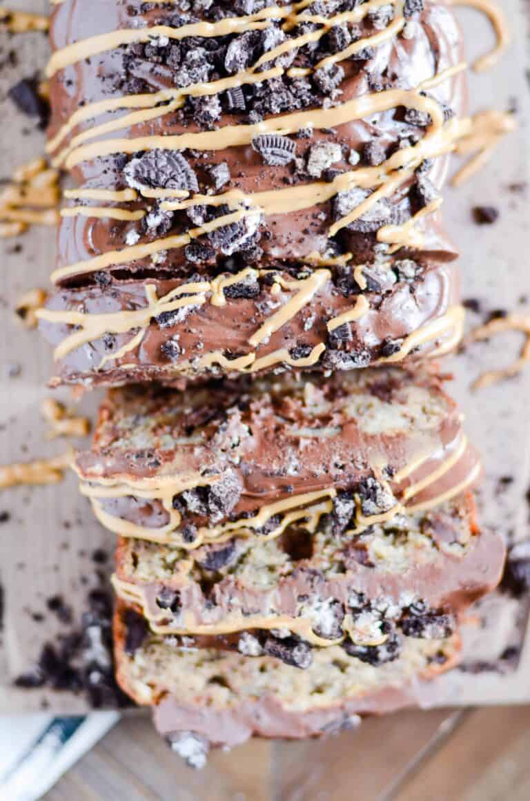 Top view of a sliced and drizzled loaf of Peanut Butter Oreo Banana Bread.