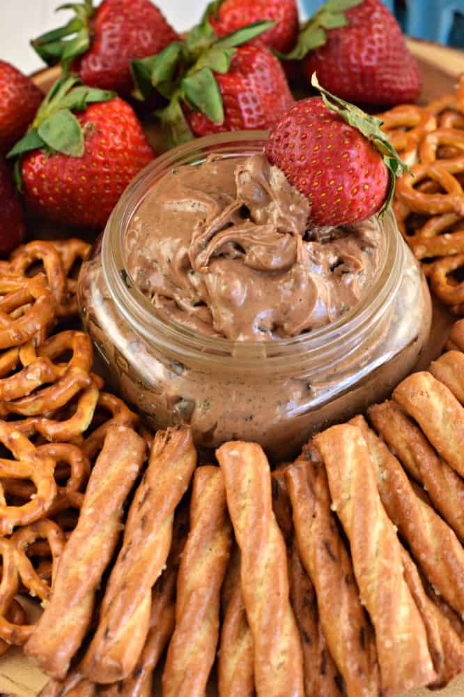 A jar of Oreo Peanut Butter Dip surrounded by fruit and pretzels.