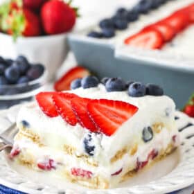 slice of berry icebox cake on white plate with blue napkin underneath