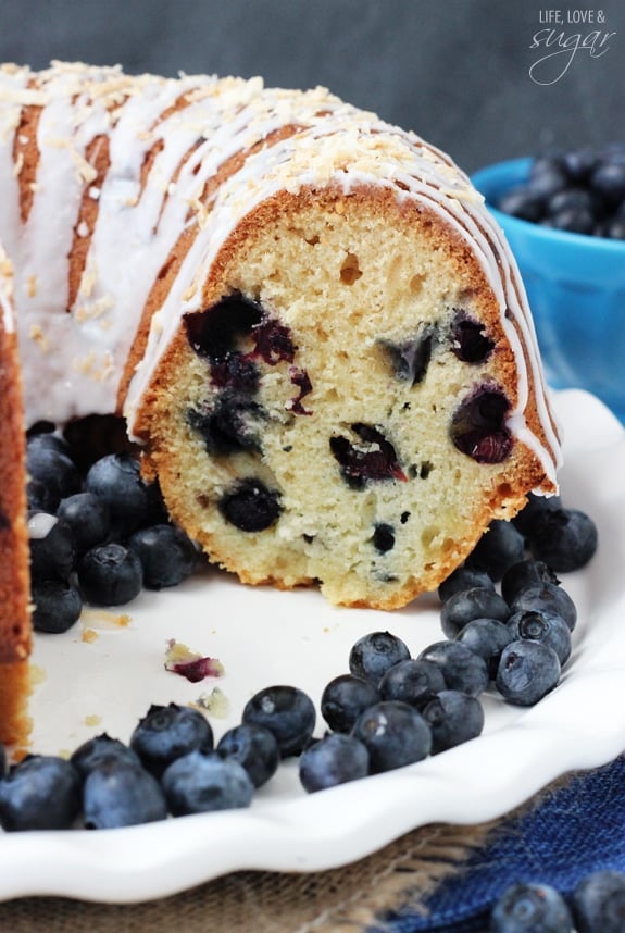 Blueberry Coconut Bundt Cake on a plate with a few slices removed