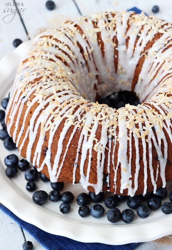 Overhead view of a whole Blueberry Coconut Bundt Cake on a plate with blueberries