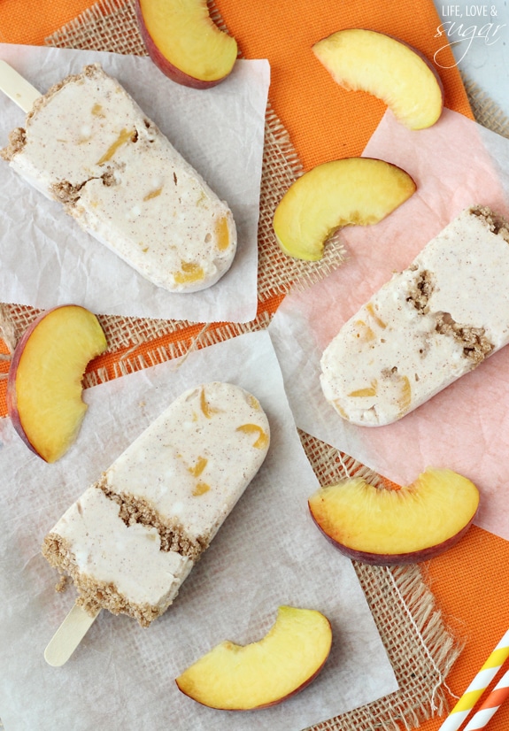 Peach Streusel Popsicles on wax paper surrounded by peach slices