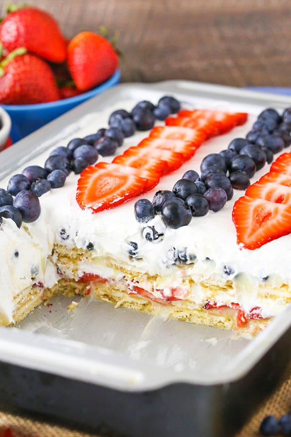 Strawberry and Blueberry Cheesecake Icebox Cake in a pan with a few pieces removed