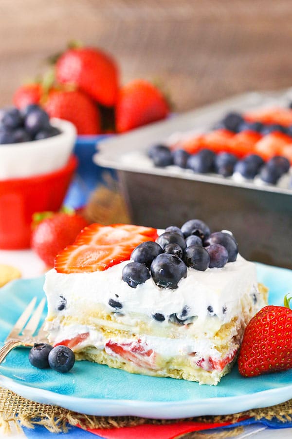 A slice of Strawberry and Blueberry Cheesecake Icebox Cake on a blue plate