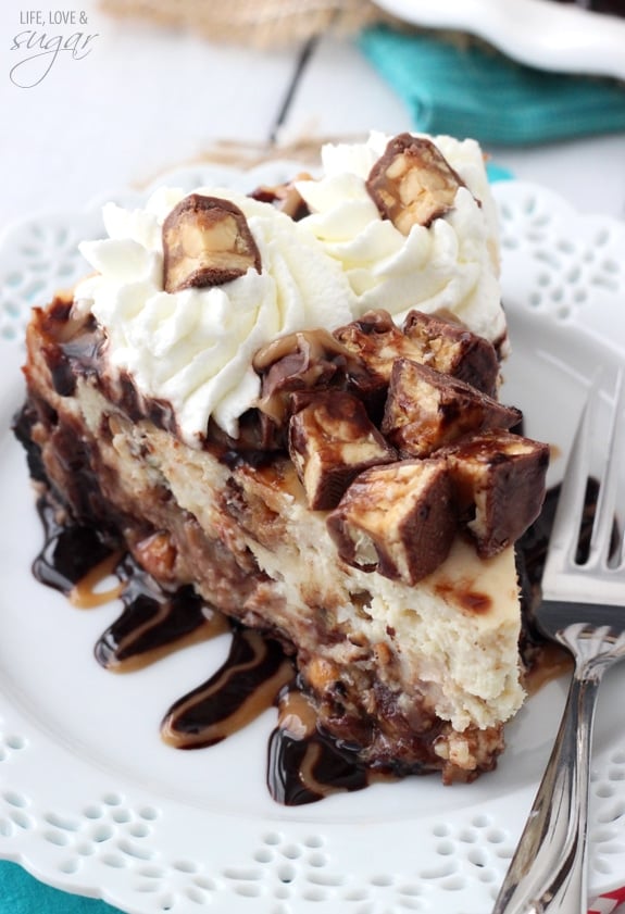 Overhead view of Snickers Cheesecake slice on a white plate