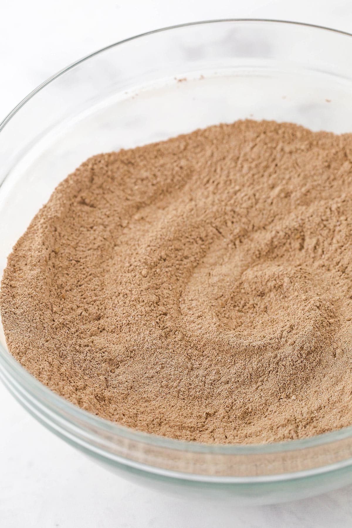 Dry ingredients for a chocolate cake in a glass bowl