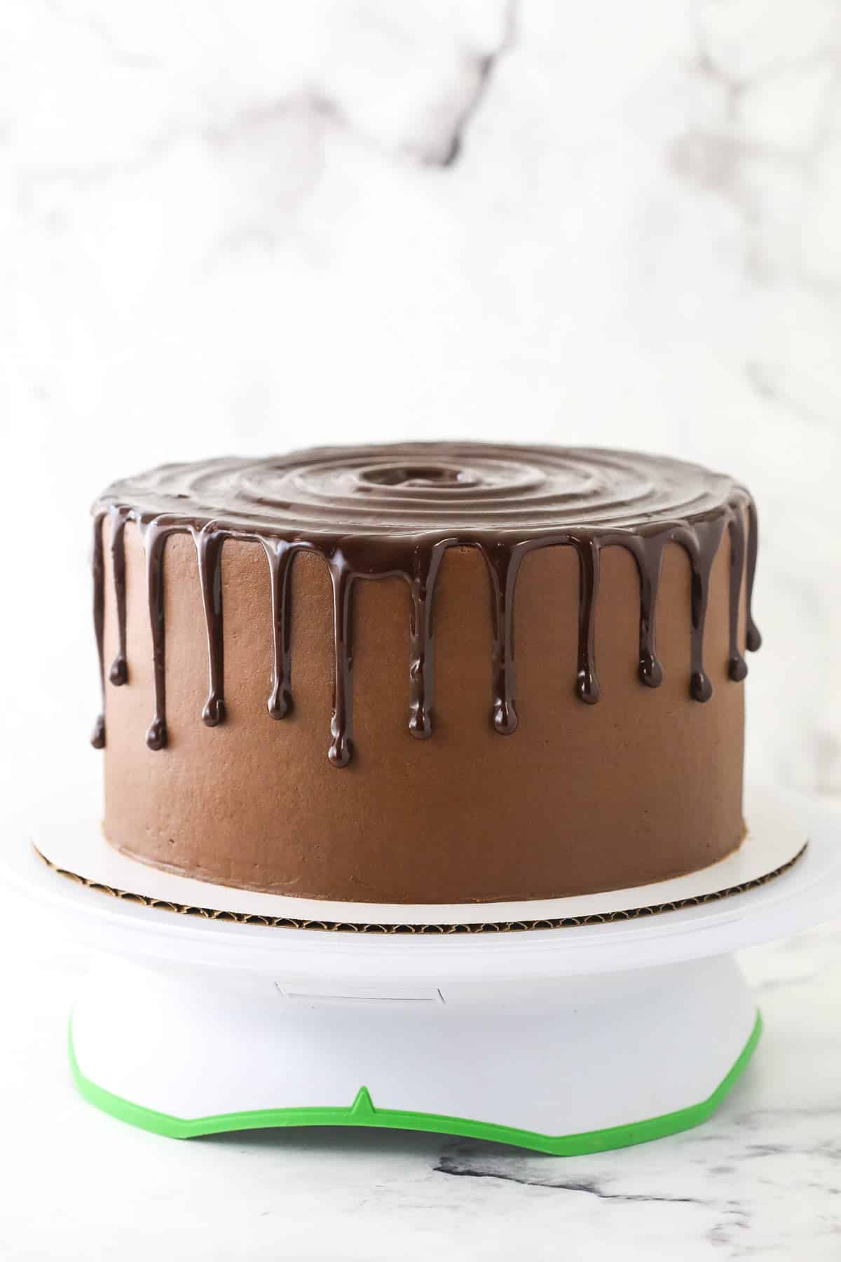 A frosted chocolate cake with ganache on top