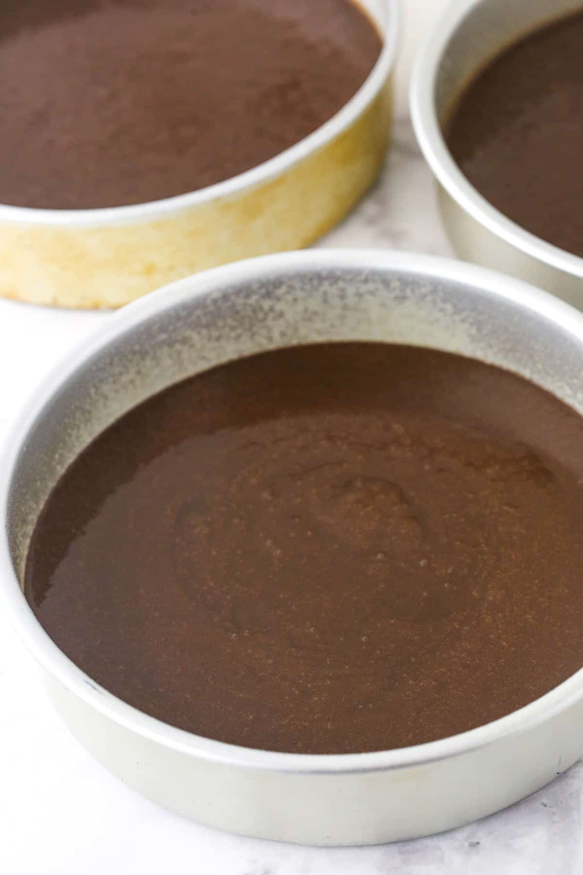 Unbaked chocolate cakes in pans ready to go into the oven