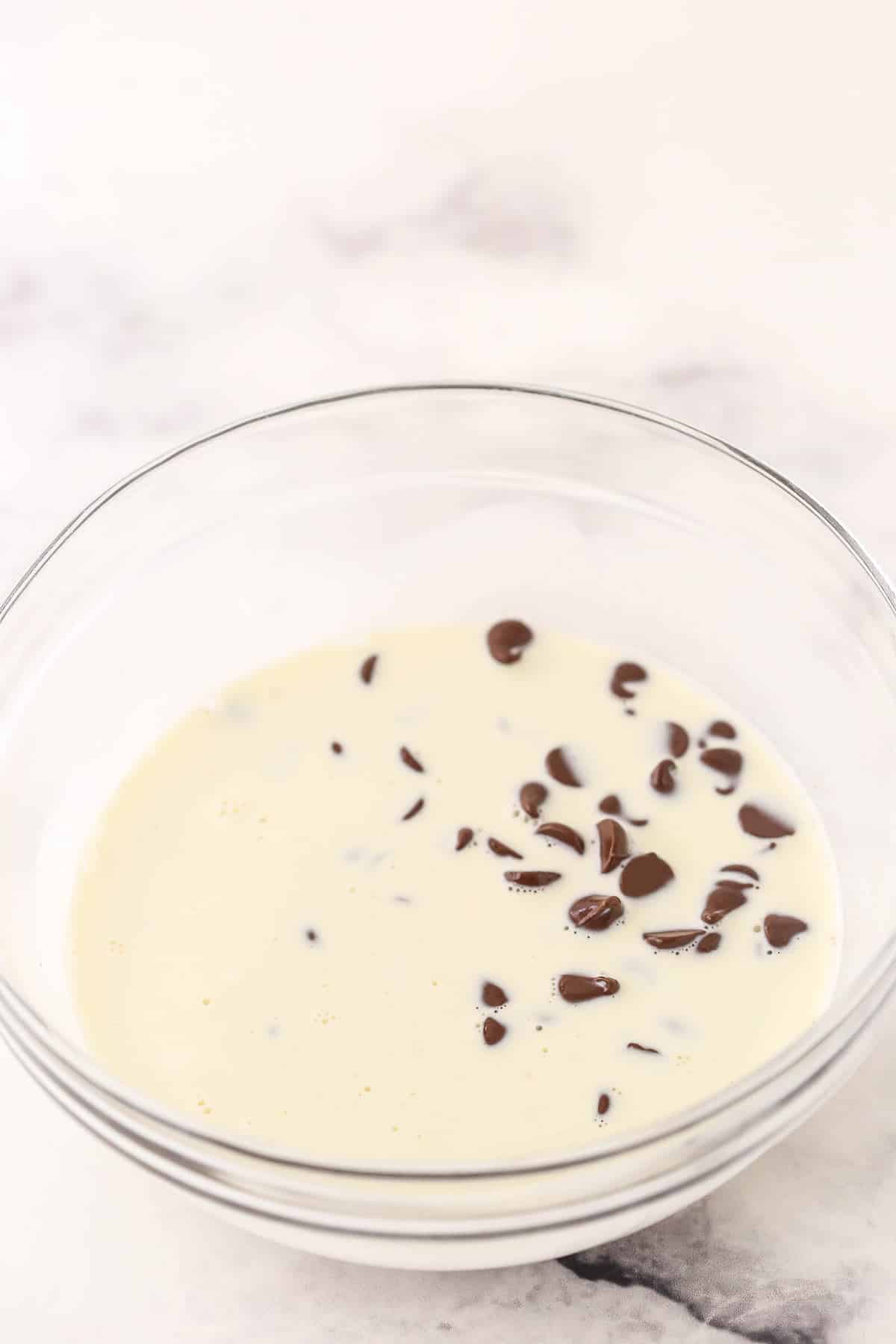 Heavy cream and chocolate chips in a glass bowl