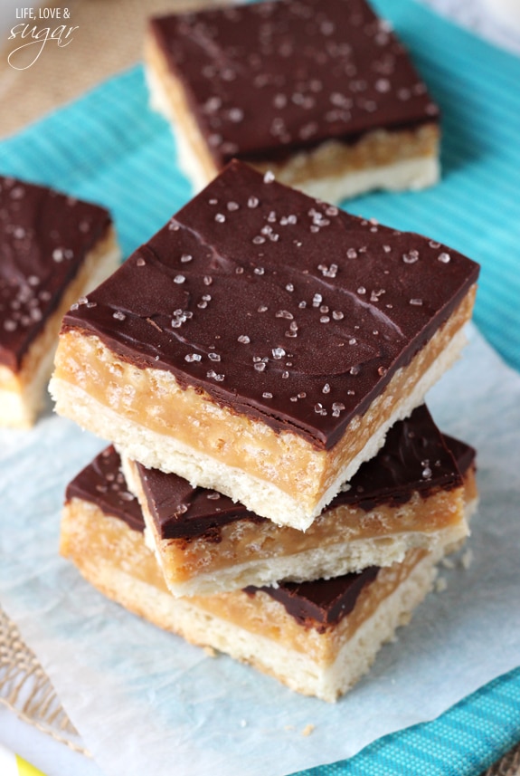 Three Millionaire's Shortbread Bars Stacked on Top of a Piece of Parchment Paper