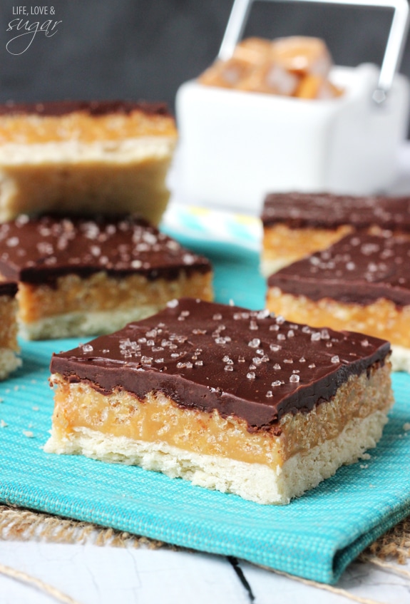 A Caramel Shortbread Bar on a Blue Kitchen Towel with More Bars