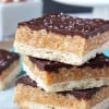 A Close-Up Shot of Three Stacked Chocolate Caramel Cookie Bars Topped with Sea Salt