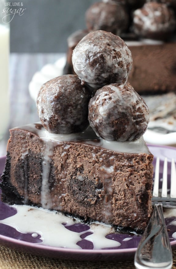 A Chocolate Donut Hole Cheesecake Slice with Vanilla Glaze on a purple plate