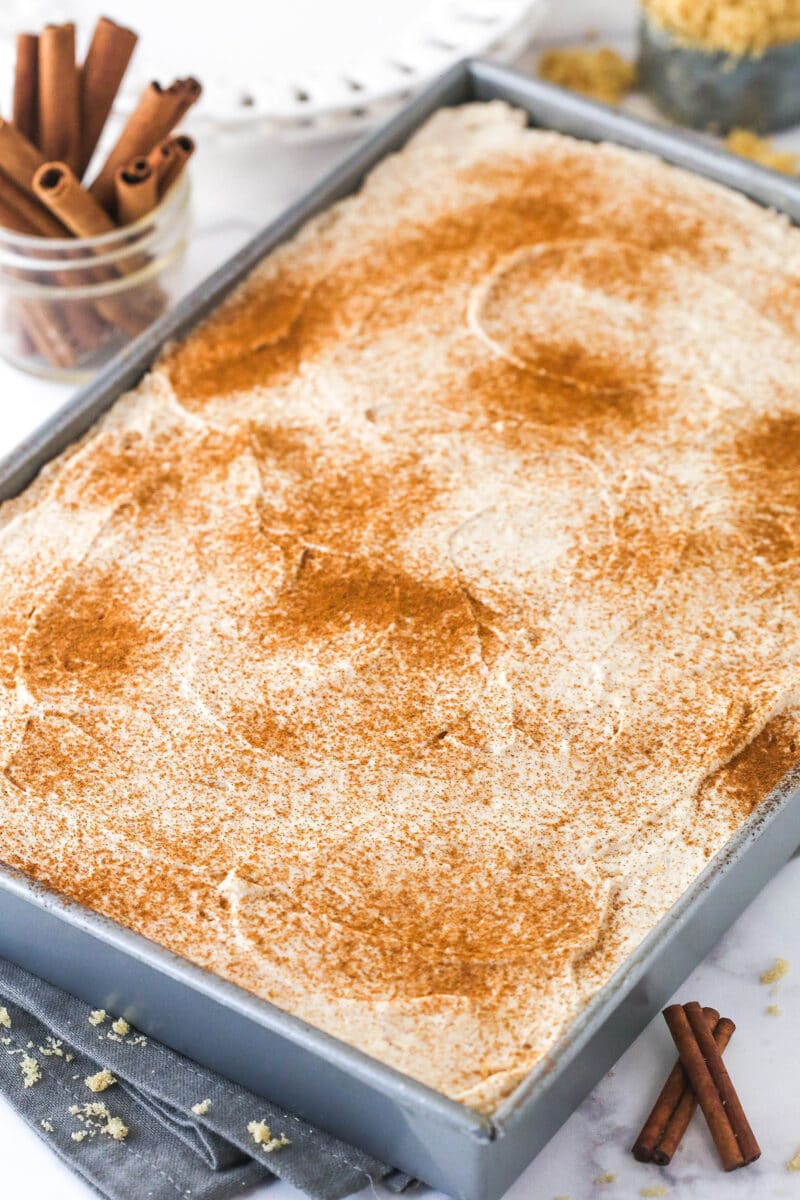 Frosted cinnamon roll poke cake in the baking dish