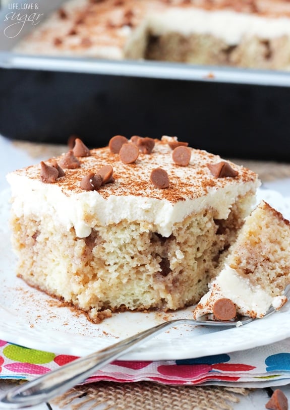 Cinnamon Roll Poke Cake on a plate with a bite on a fork