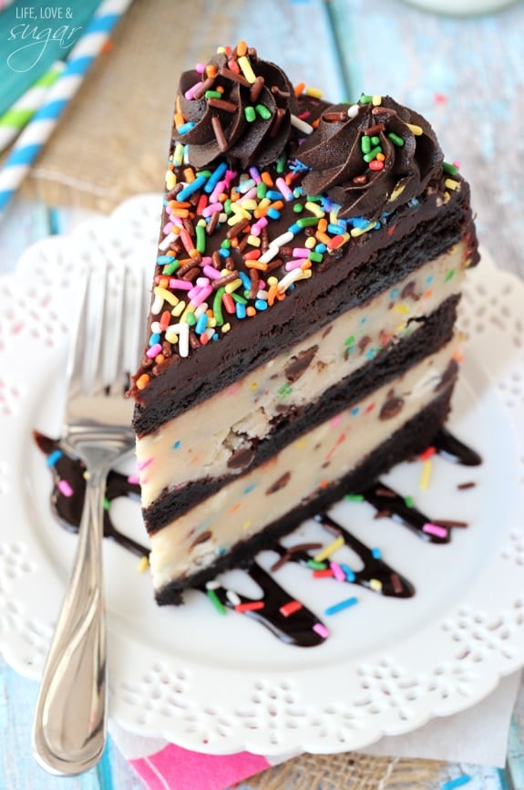 A slice of Funfetti Cake Batter Cookie Dough Brownie Layer Cake on a plate