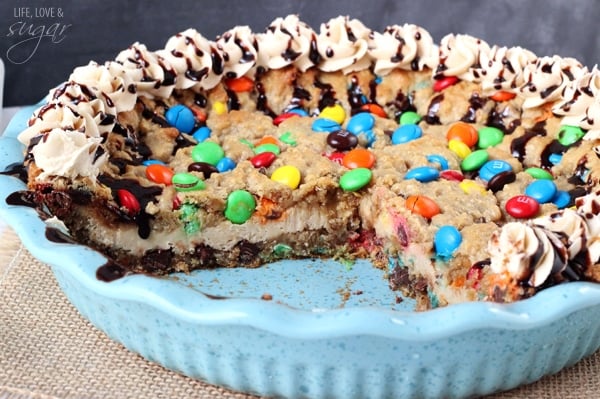 Monster Cookie Cheesecake Pie in a pie plate with a couple slices removed
