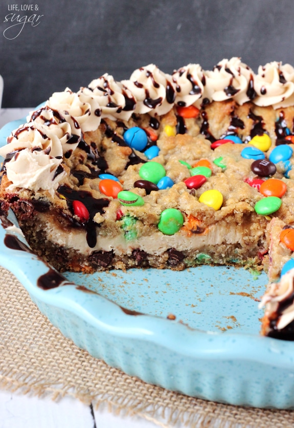 Monster Cookie Cheesecake Pie in a pie plate with a slice removed