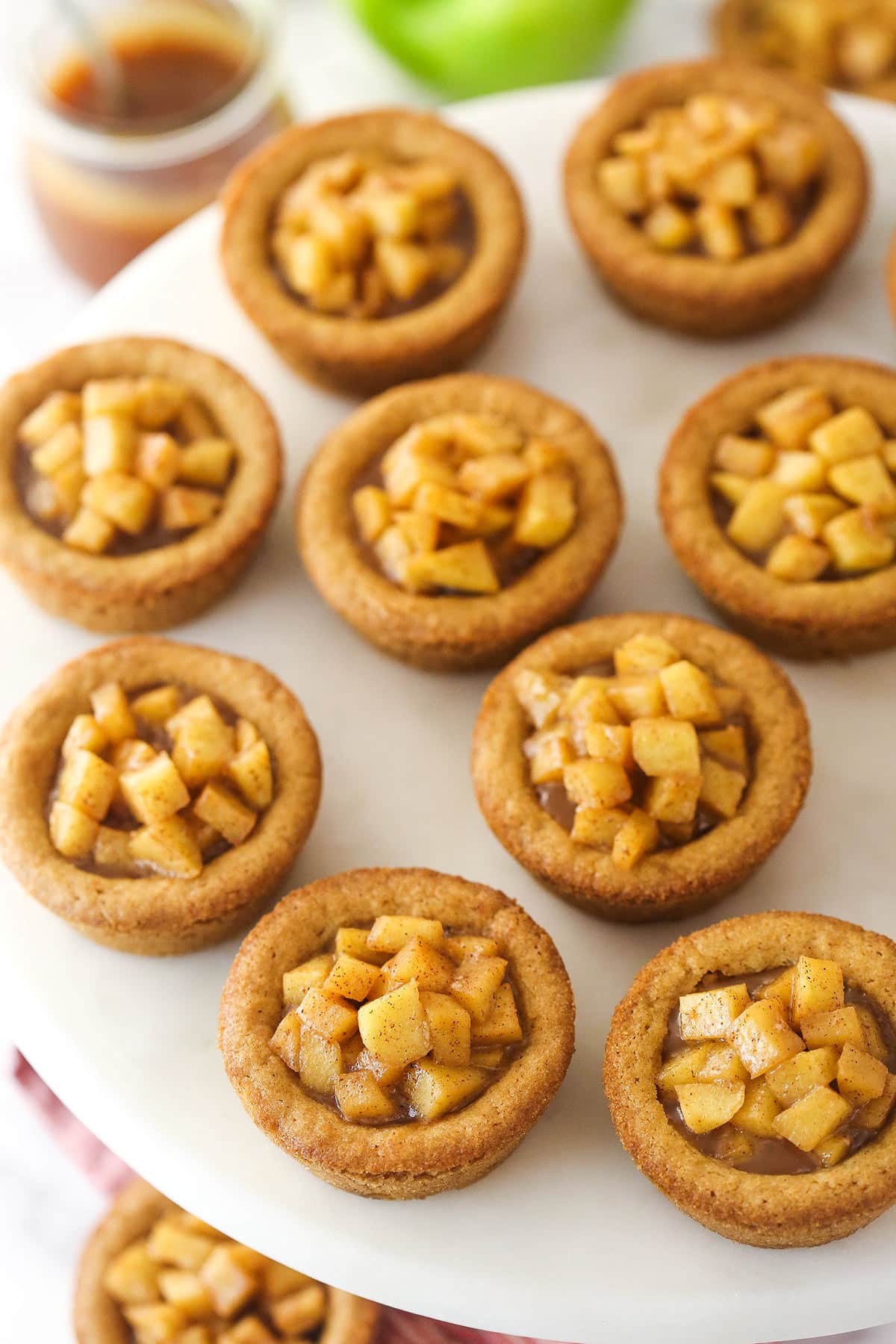 caramel apple cookie cups on marble cake stand