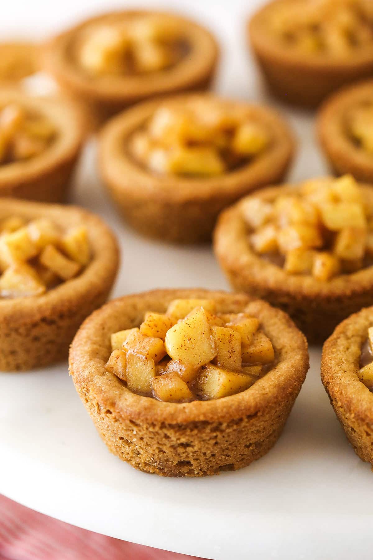 close up of caramel apple cookie cups on marble cake stand