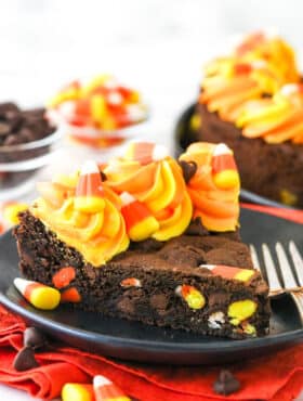 A slice of Candy Corn Chocolate Chip Cookie Cake on a small black plate.