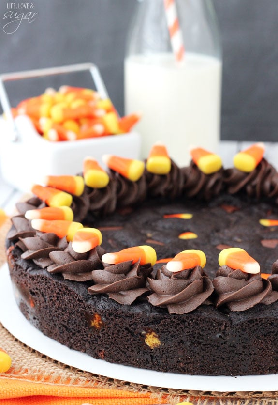 A Candy Corn Chocolate Chip Cookie Cake on a round piece of cardboard