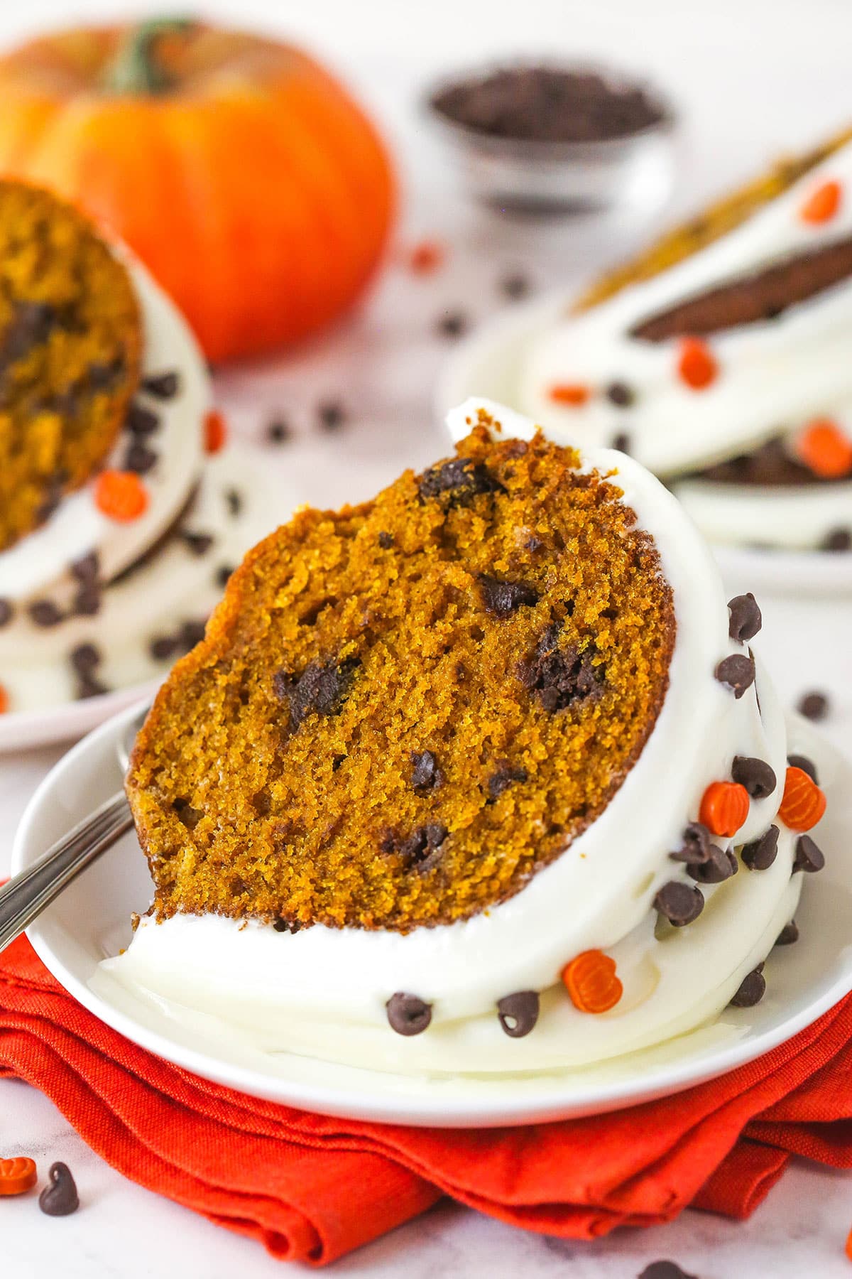 Every bite of this pumpkin chocolate chip bundt cake is moist, perfectly spiced, and dotted with chocolate chips. A slice of pumpkin chocolate chip bundt cake on a plate