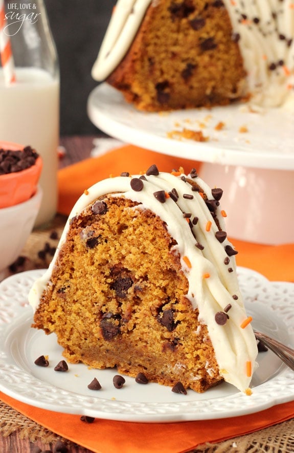 This moist and tender chocolate chip pumpkin bundt cake with cream cheese frosting is heavenly with a glass of apple cider in the fall! Pumpkin Chocolate Chip Bundt Cake slice on white plate
