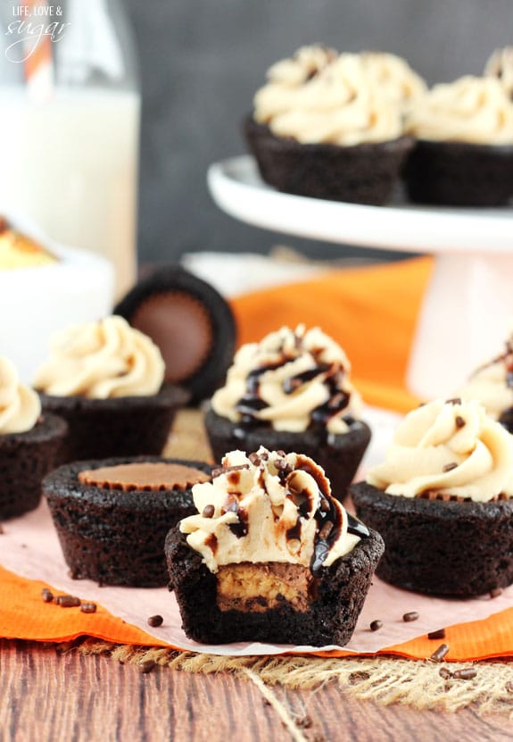 A Chocolate Cookie Cup stuffed with a Reese's Peanut Butter Cups and topped with frosting has a bite missing