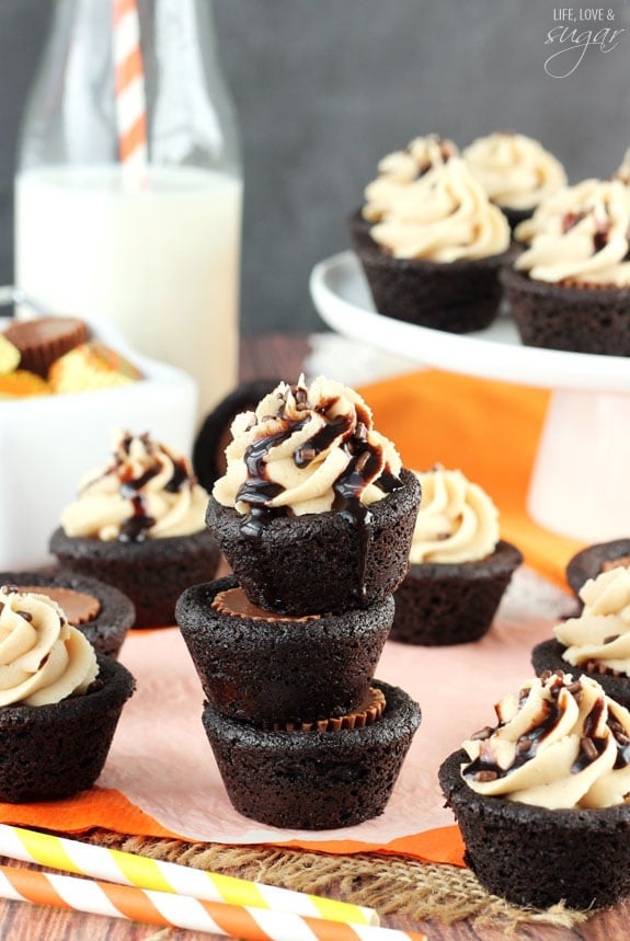 Three Chocolate Peanut Butter Cookie Cups stacked on a table with more cookies