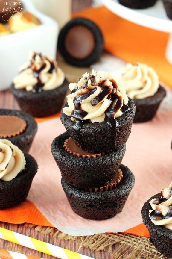 Three stacked Chocolate Cookies stuffed with a Reese's Peanut Butter Cups and the top cookie has frosting