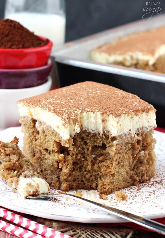 Tiramisu Poke Cake on white plate with bite on fork