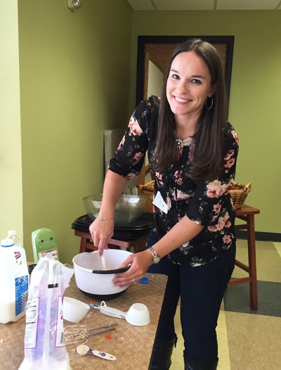 a woman mixing cupcakes in a bowl