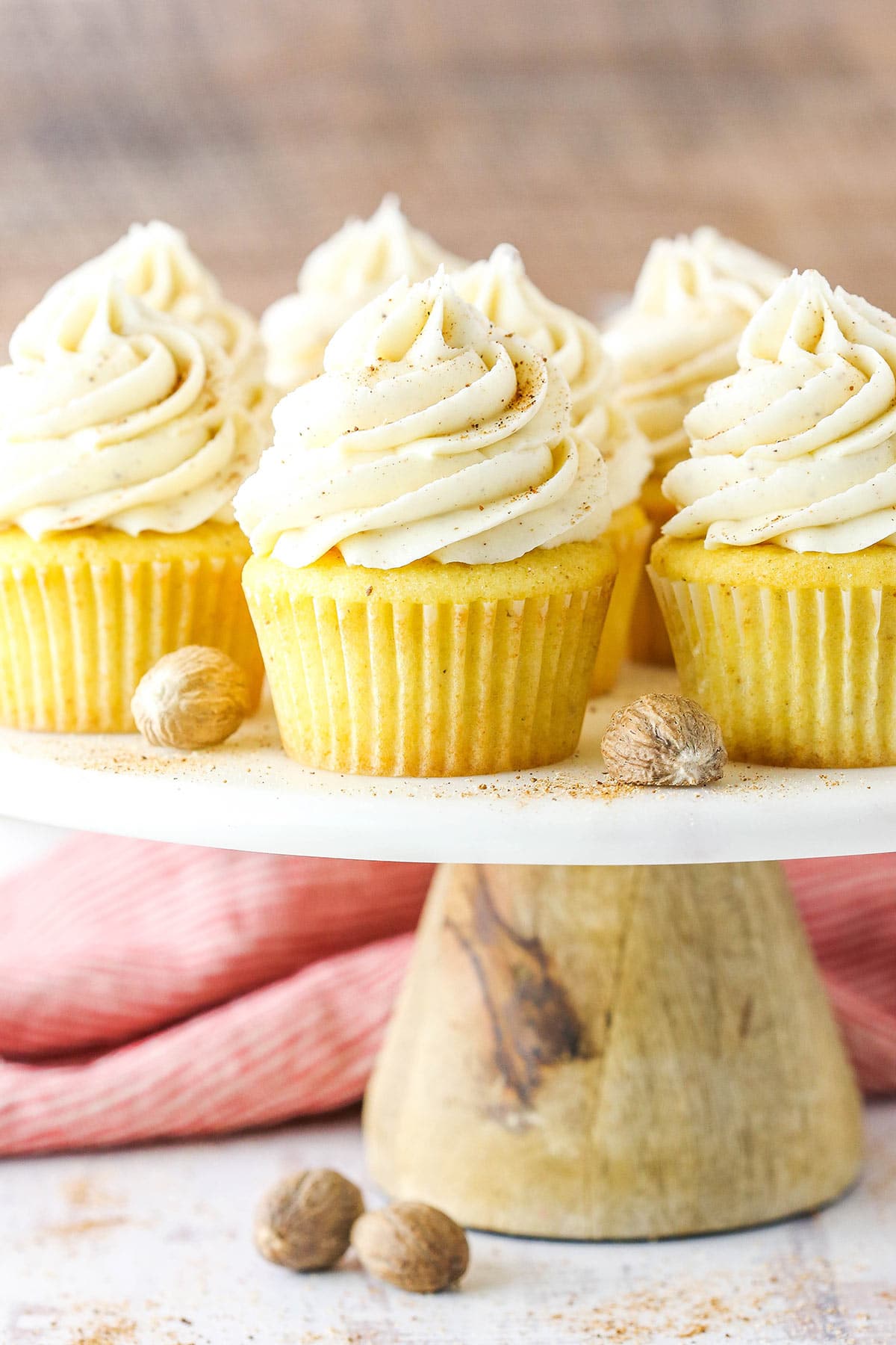 A bunch of eggnog cupcakes with eggnog frosting arranged on a cake stand