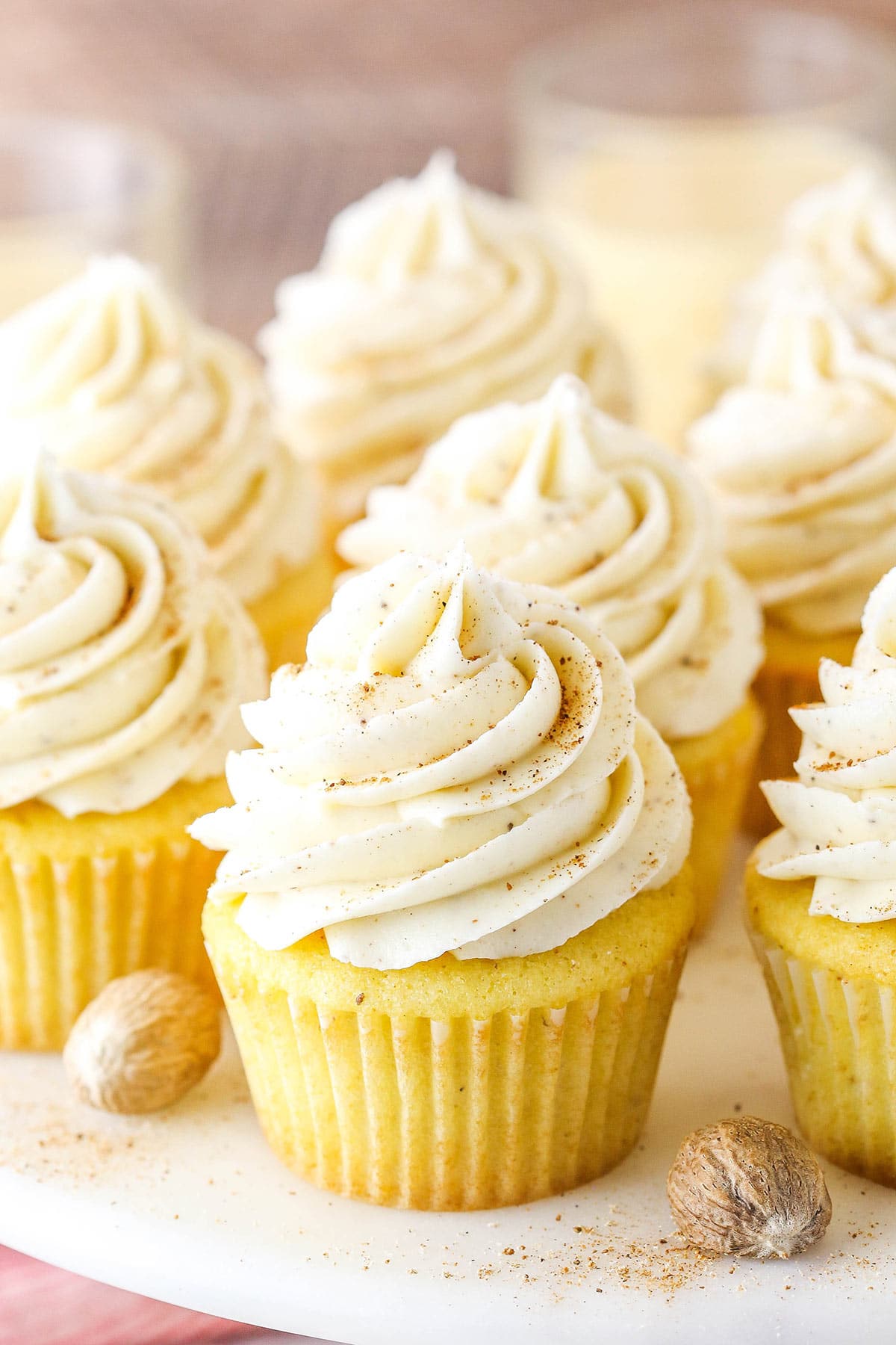 A close-up shot of Christmas eggnog cupcakes topped with a sprinkle of nutmeg