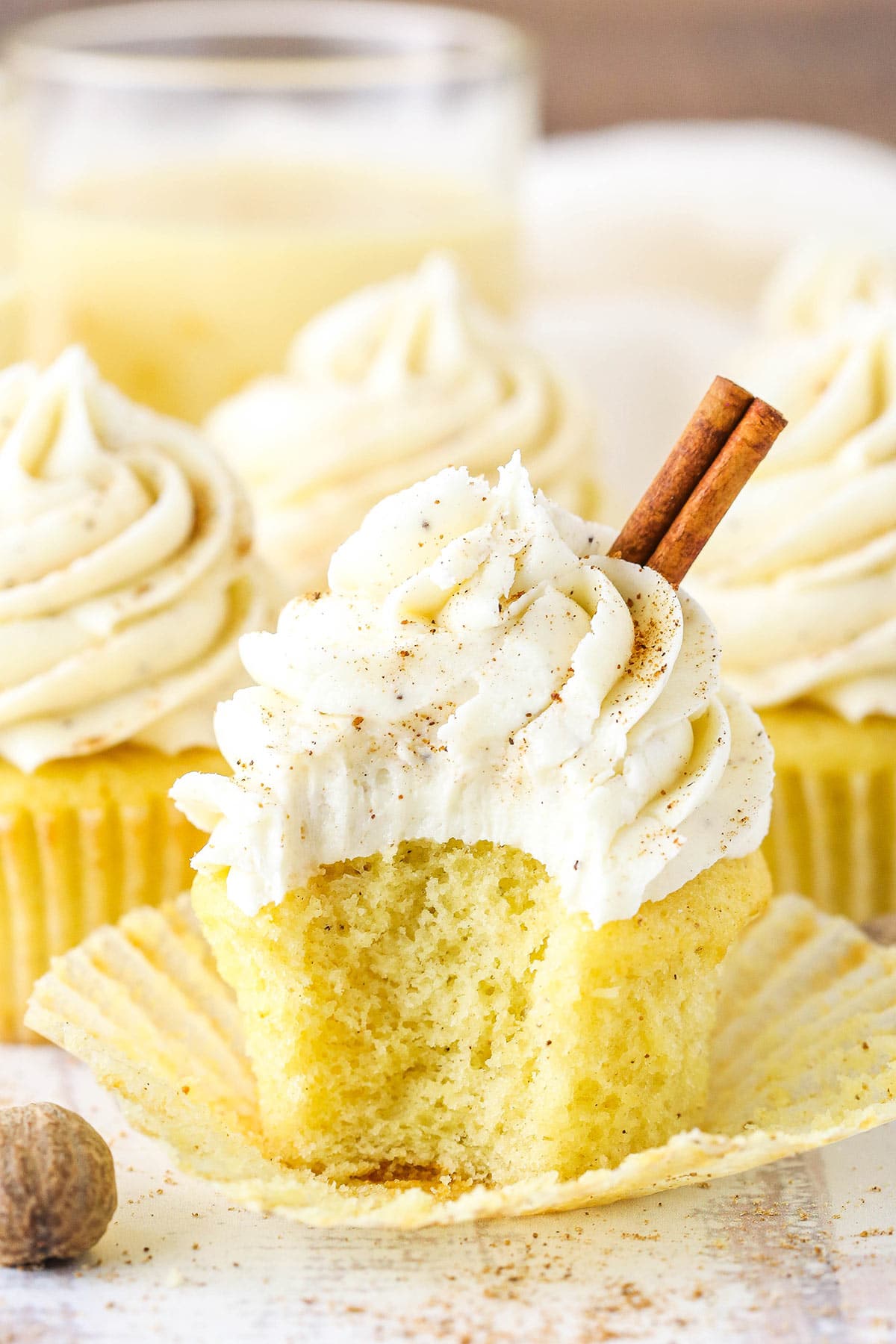 A frosted eggnog cupcake with a large bite taken out of it