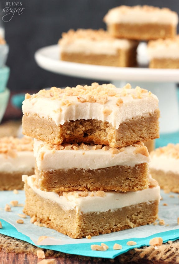 Frosted Maple Cookie Bars in a stack with a bite out of the top one