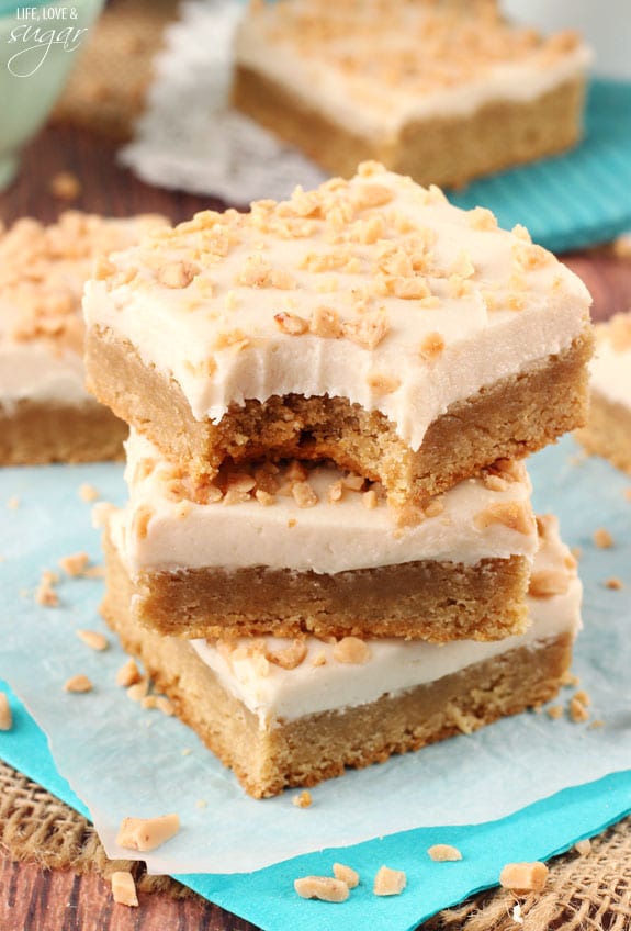 Frosted Maple Cookie Bars in a stack with a bite out of the top one