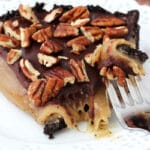 Caramel Turtle Pie Slice on white plate with bite on fork close up