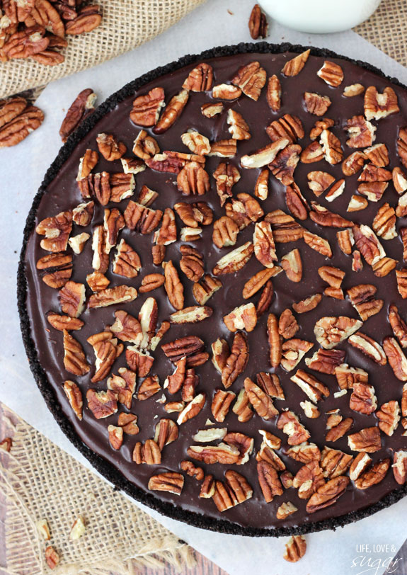 An overhead shot of a caramel turtle pie on a placemat lined with a sheet of parchment paper