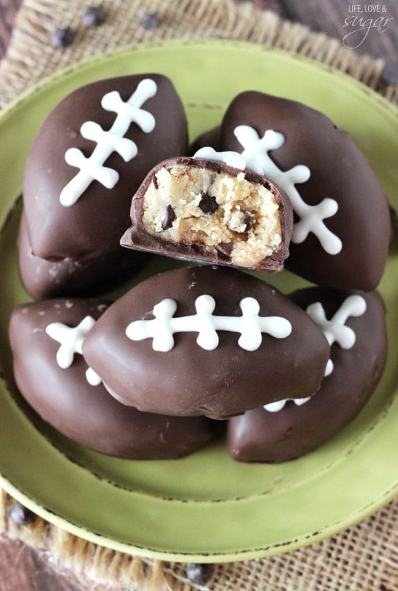 Eggless Chocolate Chip Cookie Dough Footballs on a green plate with a bite out of one