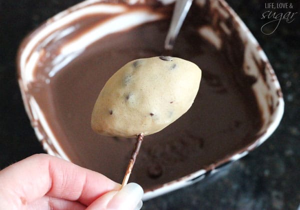 Eggless Chocolate Chip Cookie Dough Footballs being dipped in chocolate