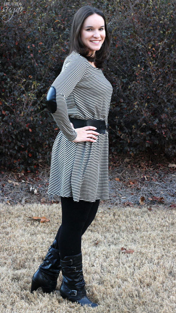 Author posing in a black and white striped dress with black belt